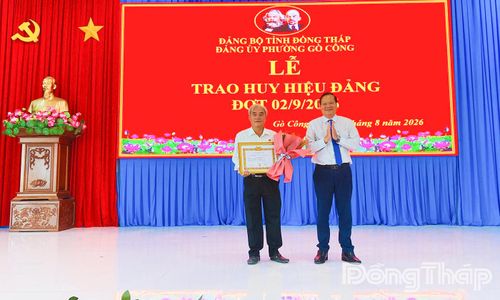 Đồng chí Nguyễn Hữu Lợi, Tỉnh ủy viên, Bí thư Đảng ủy, Chủ tịch HĐND phường Gò Công, trao Huy hiệu 35 năm tuổi Đảng cho đảng viên tại địa phương.