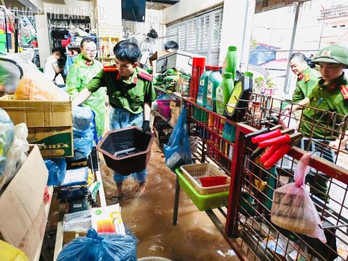 Lực lượng công an xã Na Sầm hỗ trợ tiểu thương di chuyển tài sản ra khỏi khu vực ngập lụt
