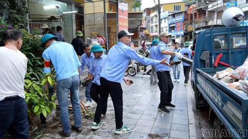 Lực lượng của Trung tâm Dịch vụ tổng hợp phường Sa Pa giải tỏa vật liệu, đồ đạc lấn chiếm vỉa hè, trả lại lối đi thông thoáng cho người dân và du khách.