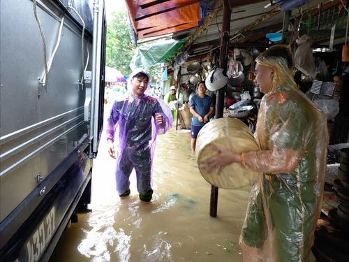 Cán bộ Công an phường Đông Kinh hỗ trợ người dân di chuyển tài sản khỏi khu vực ngập úng tại chợ Giếng Vuông
