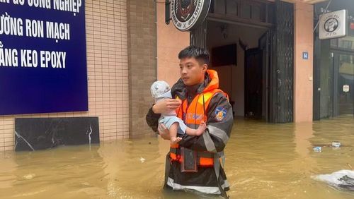 Chiến sĩ Công an di chuyển cháu bé sơ sinh đến nơi an toàn. (Ảnh: Hùng Chu)