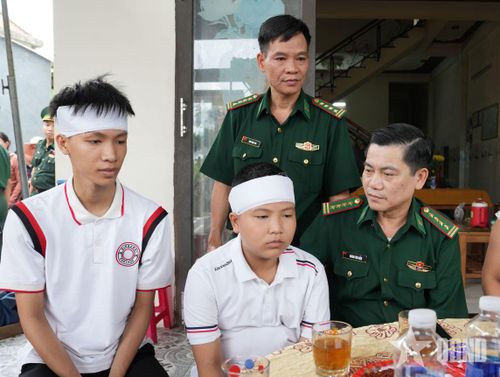 Đại tá Hoàng Văn Mẫn (ngồi) thăm hỏi 2 cháu Lê Viết Hồng Anh và Lê Viết Hồng Pháp.