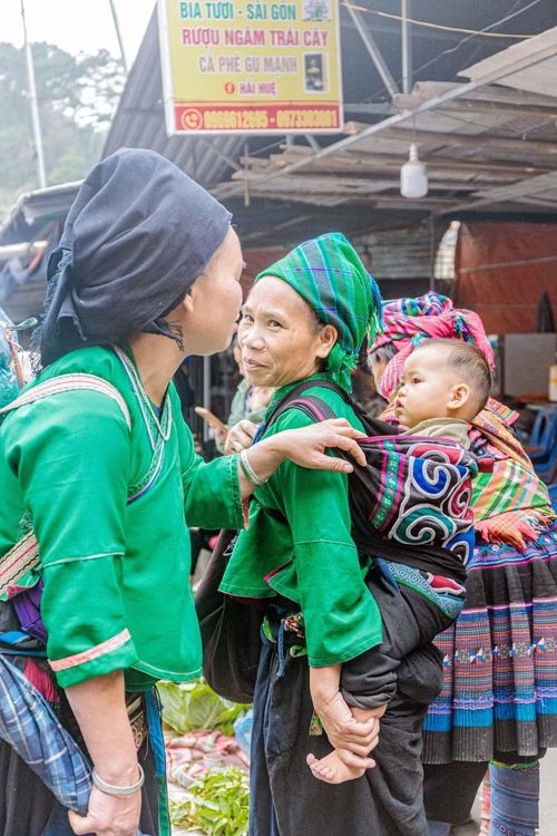 Những đứa trẻ được địu xuống chợ phiên.