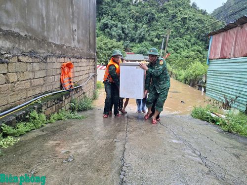 Cán bộ, chiến sĩ Đồn Biên phòng cửa khẩu Tân Thanh hỗ trợ người dân di dời tài sản đến nơi an toàn. Ảnh: Vi Toàn