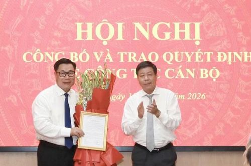 Phó Chủ tịch Thường trực UBND thành phố Dương Đức Tuấn trao quyết định, tặng hoa chúc mừng tân Giám đốc Sở Nội vụ Hà Nội Nguyễn Quang Hiếu. Ảnh: Đình Hiệp
