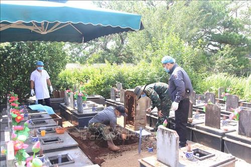 Các lực lượng chức năng tổ chức lấy mẫu ADN tại Nghĩa trang liệt sĩ Đăk Đoa, tỉnh Gia Lai. Ảnh: Quang Thái/TTXVN