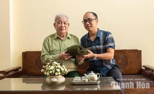 Cựu chiến binh Trịnh Quốc Đạt trao tặng kỷ vật cho cán bộ Phòng Sưu tầm, Kiểm kê và Bảo quản (Trung tâm Bảo tồn di sản, Bảo tàng và Thư viện tỉnh Thanh Hóa).