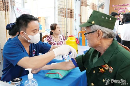 Một cựu chiến binh ở xã Bình Minh được nhân viên y tế lấy máu làm xét nghiệm khám sàng lọc sức khỏe. Ảnh: Bảo Hân