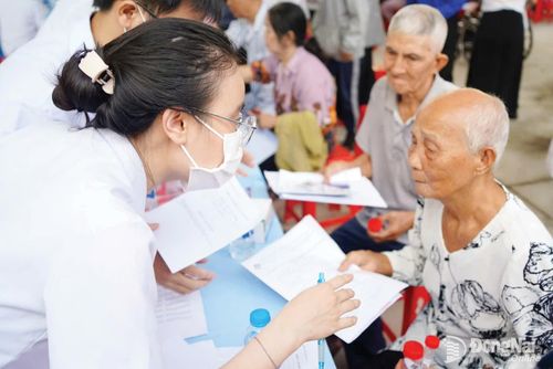 Nhân viên y tế lấy thông tin của người dân ở phường Trị An để cập nhật hồ sơ khám sức khỏe. Ảnh: Lê Duy