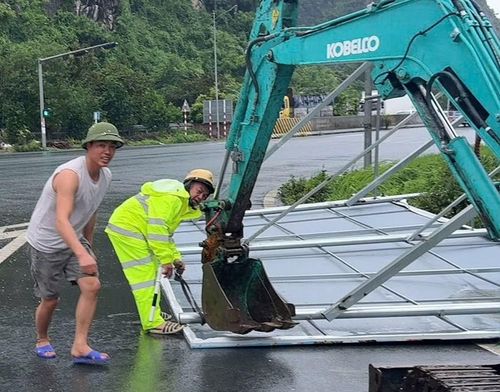 Cảnh sát giao thông Hải Phòng giải tỏa biển quảng cáo lớn bị gió giật đổ để thông đường.