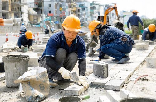 Các công nhân lát đá vỉa hè khu vực từ nút giao Giảng Võ - Láng Hạ đến đường Nguyễn Chí Thanh.