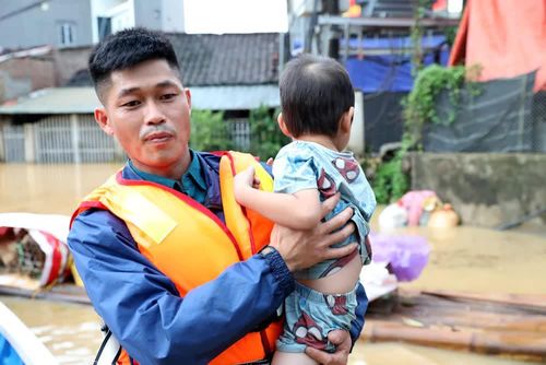 Lực lượng chức năng xã Tràng Định, tỉnh Lạng Sơn hỗ trợ đưa trẻ em từ vùng lũ đến nơi an toàn