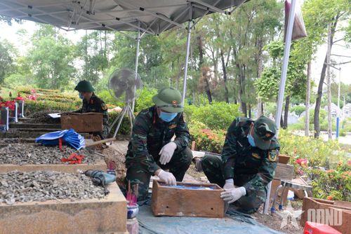 Tổ lấy mẫu hài cốt liệt sĩ tại Nghĩa trang Liệt sĩ TP Huế thực hiện các bước khai quật, mở nắp mộ.