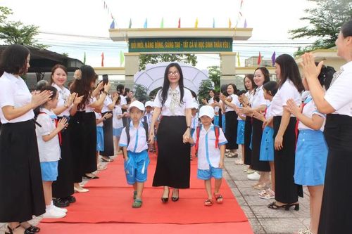 Ban giám hiệu cùng đón học sinh tại cổng trường trước.