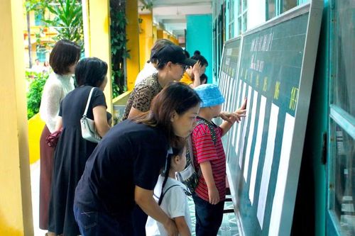 Phụ huynh cùng con xem danh sách lớp.