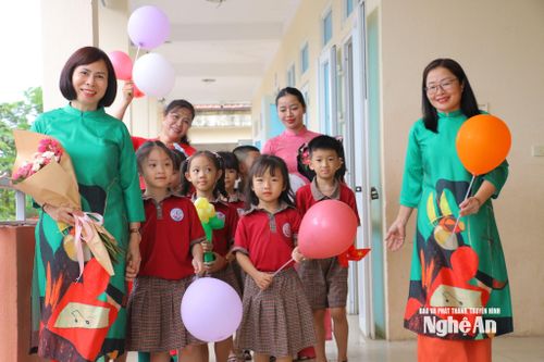 Các em Trường Tiểu học Hưng Lộc, phường Vinh Lộc được giáo viên chào đón trong niềm hân hoan, vui mừng. Ảnh: Mỹ Hà