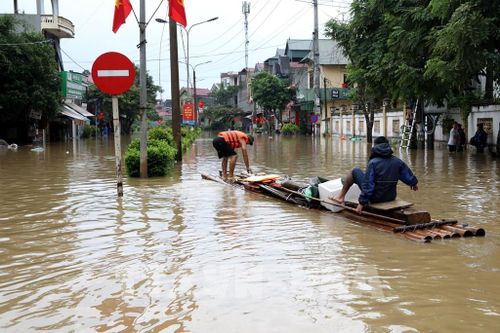 Người dân xã Thất Khê, tỉnh Lạng Sơn di chuyển bằng bè trên Quốc lộ 4A. Ảnh: Văn Đạt - TTXVN