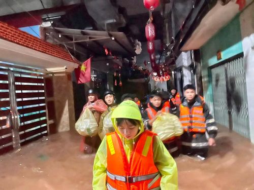 Hội viên phụ nữ Công an tỉnh Lạng Sơn dầm mưa đưa suất cơm nóng cho người dân mắc kẹt ở những nơi lũ bủa vây.