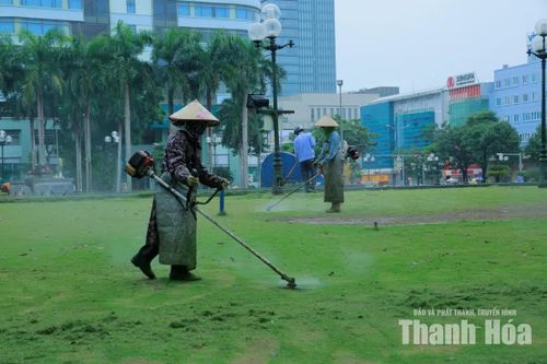 Công nhân chỉnh trang thảm cỏ và hoa ở khu vực tượng đài Lê Lợi.