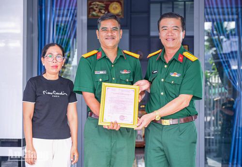 Đại tá Nguyễn Việt Thắng, Chính ủy Bộ Chỉ huy Quân sự tỉnh An Giang trao quyết định bàn giao nhà cho gia đình Thiếu tá quân nhân chuyên nghiệp Liêu Đạt.