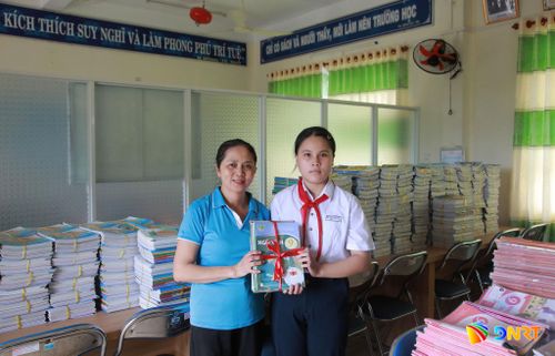 Em Phan Ngọc Kiều Ly (học sinh lớp 9/3) với niềm vui nhận sách mới. Ảnh: ĐẮC MẠNH