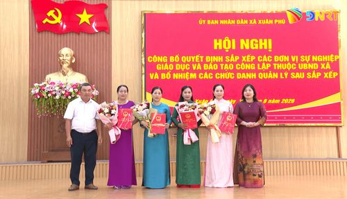 Lãnh đạo xã Xuân Phú trao quyết định và tặng hoa cho tập thể lãnh đạo Trường Mầm non Xuân Phú. Ảnh: LAM KHUÊ