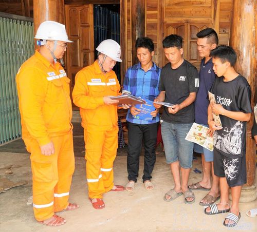 Công nhân điện lực tuyên truyền người dân sử dụng điện an toàn, tiết kiệm trên địa bàn xã Mường Tùng. (Ảnh CTV)