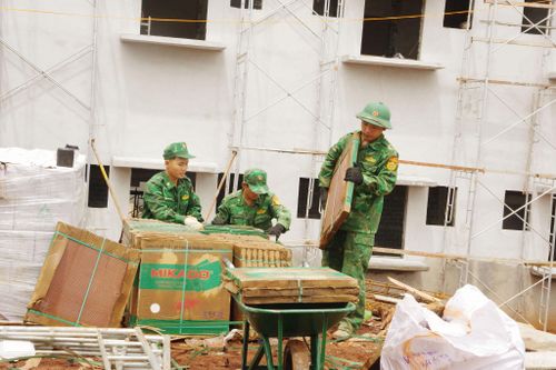 Các chiến sĩ vận chuyển vật liệu ốp lát khu phòng học Trường phổ thông nội trú liên cấp Tiểu học và Trung học cơ sở Quảng Trực