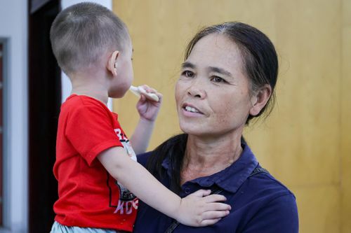 Bà Tuyết cùng cháu nội 2 tuổi được đưa đến nhà khách An Sơn an toàn trong mưa lũ.