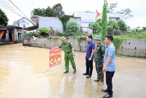Chủ tịch UBND xã Xuân Mai Nguyễn Anh Đức kiểm tra, chỉ đạo lực lượng chức năng cắm biển cảnh báo người và phương tiện không đi vào khu vực ngập sâu. Ảnh: Hoàng Tình