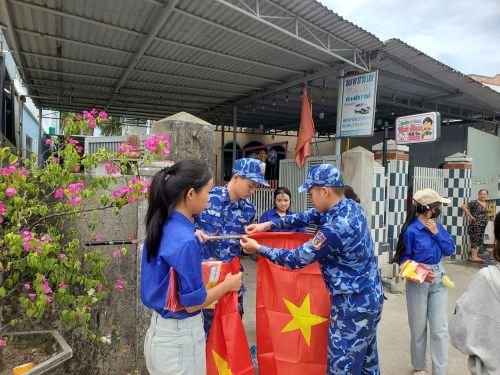 Các chiến sĩ và đoàn viên thôn cùng treo cờ Tổ quốc
