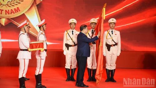Phó Thủ tướng Thường trực Chính phủ Phạm Gia Túc gắn Huy hiệu Anh hùng Lực lượng vũ trang nhân dân lên Cờ truyền thống của Công an thành phố Đà Nẵng.
