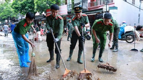  Lực lượng chức năng hỗ trợ người dân khắc phục bùn đất tại các điểm ngập khi nước lũ rút dần, ngày 24-8. Ảnh: Công an tỉnh Lạng Sơn 