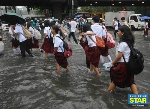 Học sinh lội qua dòng nước ngập tại góc giao đường Taft và UN ở Manila năm 2025. (Nguồn: The Philippine STAR)