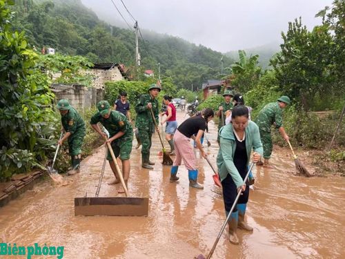 Cán bộ, chiến sĩ Đồn Biên phòng Pò Mã phối hợp với nhân dân vệ sinh đường làng, ngõ xóm sau lũ. Ảnh: Đơn vị cung cấp
