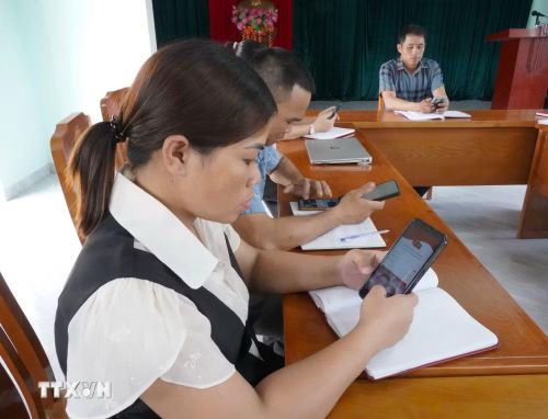 Đảng viên tra cứu tài liệu trên điện thoại thông minh. (Ảnh: Thanh Thủy/TTXVN)