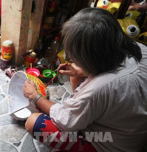 Vẽ trang trí đầu lân ở cở sở ông Cao Xuân Dũng, phường Phú Xuân, thành phố Huế. Ảnh: Nguyên Lý - TTXVN