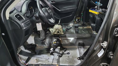 Một chiếc xe ô tô bị tràn nước vào trong xe qua ống thoát nước cửa sổ trời, thợ xe tháo toàn bộ ghế, nỉ sản ra sấy khô, kiểm tra, xử lý các giắc cắm điện (Ảnh: Đỗ Quang).