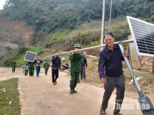 Cán bộ, chiến sĩ Đồn Biên phòng Tam Chung cùng người dân lắp đặt đèn năng lượng mặt trời tại bản Ón.