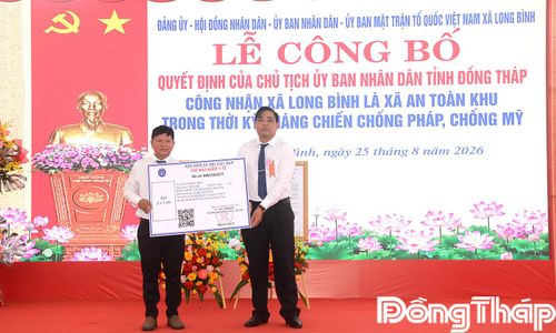 Đồng chí Châu Anh Vũ, Phó Chủ  tịch UBND xã Long Bình trao bảng tượng trưng bảo hiểm y tế cho đại diện hộ dân.  