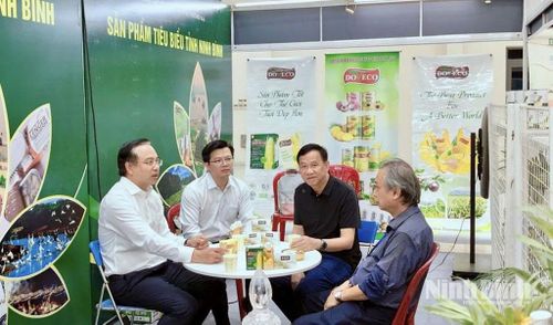 Đồng chí Đặng Thanh Sơn, Ủy viên Ban Thường vụ Tỉnh ủy, Phó Chủ tịch UBND tỉnh Ninh Bình trao đổi với lãnh đạo Trung tâm Xúc tiến đầu tư và thương mại tỉnh cùng các doanh nghiệp tại gian hàng.