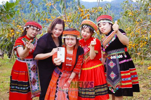 Du khách trong bộ trang phục dân tộc chụp ảnh tại vườn hồng.