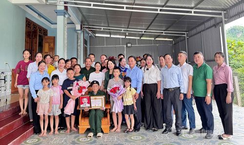 Phó Trưởng đoàn ĐBQH chuyên trách tỉnh Lý Thị Lan trao Huy hiệu 65 năm tuổi Đảng và chụp ảnh lưu niệm cùng đảng viên Lý Văn Hoa, Chi bộ thôn Phúc Ninh, xã Xuân Vân.