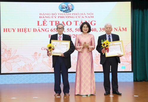 Phó Bí thư Thường trực Đảng ủy phường Phạm Thị Thu Thủy trao Huy hiệu Đảng tặng các đảng viên lão thành. Ảnh: PV