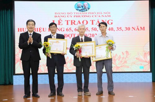 Chủ tịch UBND phường Nguyễn Quốc Hoàn trao Huy hiệu Đảng tặng các đảng viên lão thành. Ảnh: PV