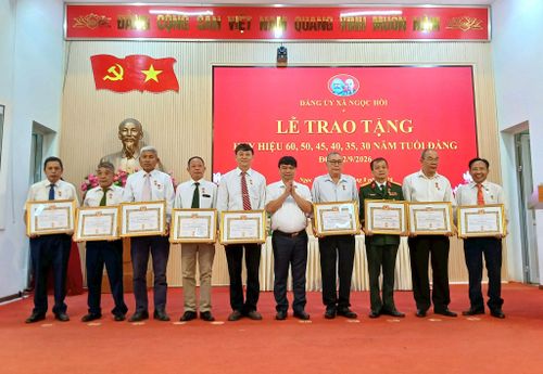 Chủ tịch UBND xã Ngọc Hồi Trần Việt Trung trao Huy hiệu Đảng cho các đảng viên. Ảnh: Hoàng Quyết