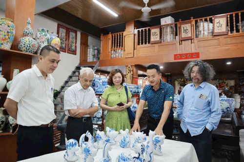 Nghệ nhân Hà Mạnh Tiến (thứ 2 từ phải sang) giới thiệu bộ sản phẩm 12 con giáp. Ảnh: Nguyễn Mai