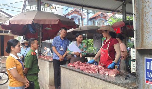 Lực lượng chức năng xã Hòa Xá kiểm tra an toàn thực phẩm tại chợ Đình Xuyên. Ảnh: TTVH