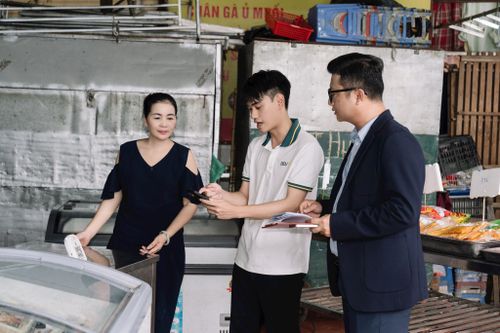 Hộ kinh doanh tại chợ được hướng dẫn trực tiếp quy trình xác nhận giao dịch số ngay tại quầy hàng. Ảnh: PV