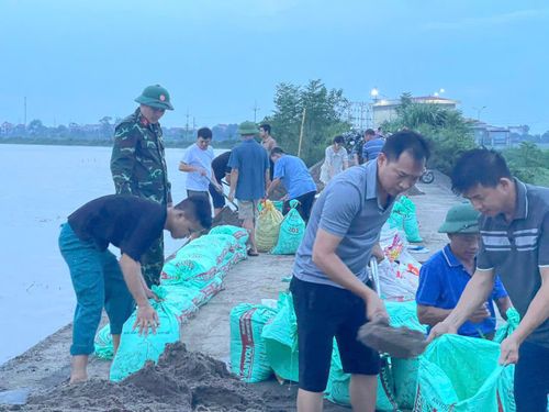 Lực lượng xung kích và nhân dân xã Trần Phú tham gia chống tràn đê Bùi 2 chiều tối 24-8. Ảnh: Hồng Đào